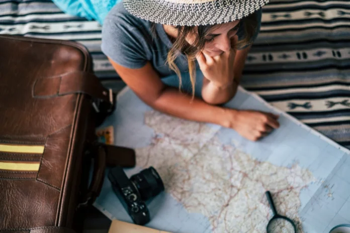 How to Find Cheap Flights: A Practical Guide That Actually Works Choose Cheap Flight for Travel” — A traveler studies a map with camera and gear nearby, planning an affordable journey